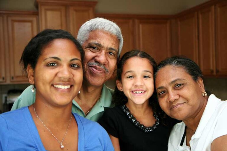 Family of 4 people smiling into the camera